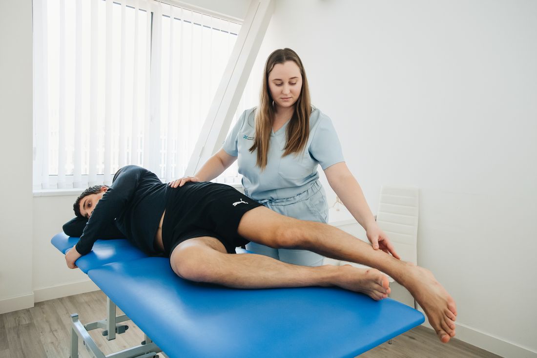Fisioterapeuta realizando terapia manual em paciente deitado durante avaliação