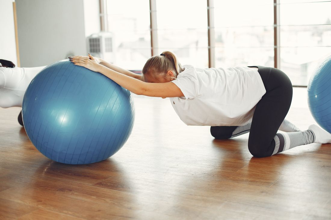 Gestante em exercicio de alongamento em ambiente claro